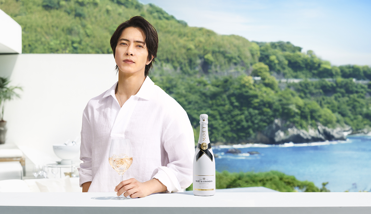 爽やかなホワイトシャツを纏った山下智久が夏らしい海を背景に 